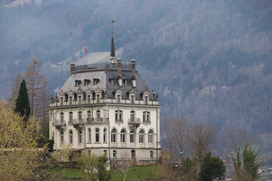 Façade d'un hôtel de luxe historique suisse avec drapeaux et jardins