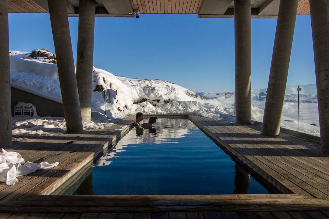 Piscine thermale extérieure fumante entourée de montagnes suisses en hiver